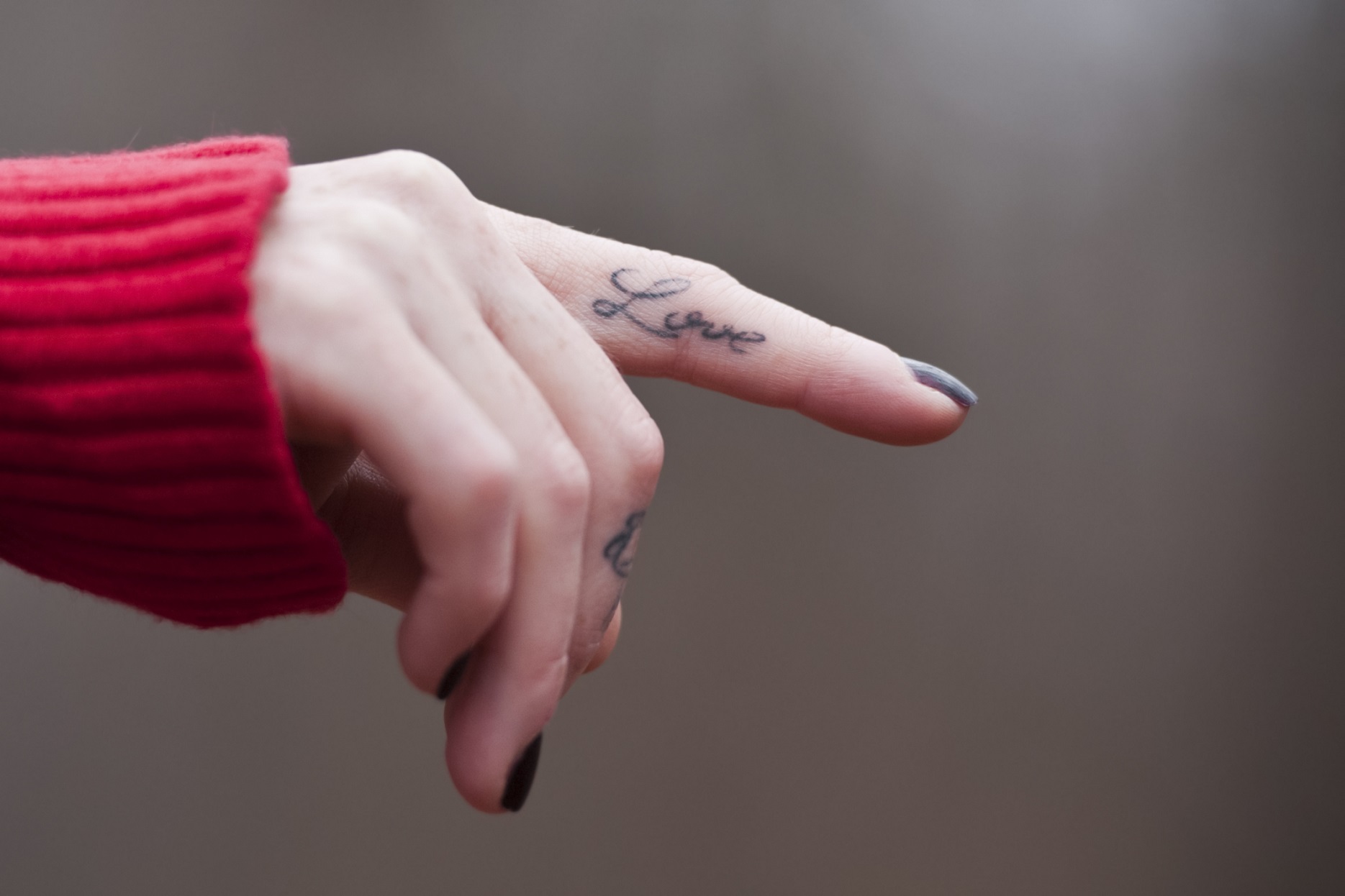 Love tattoo on a female finger