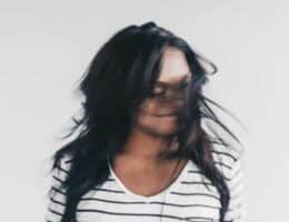 Giovane donna mette in mostra i suoi capelli dopo cura naturale