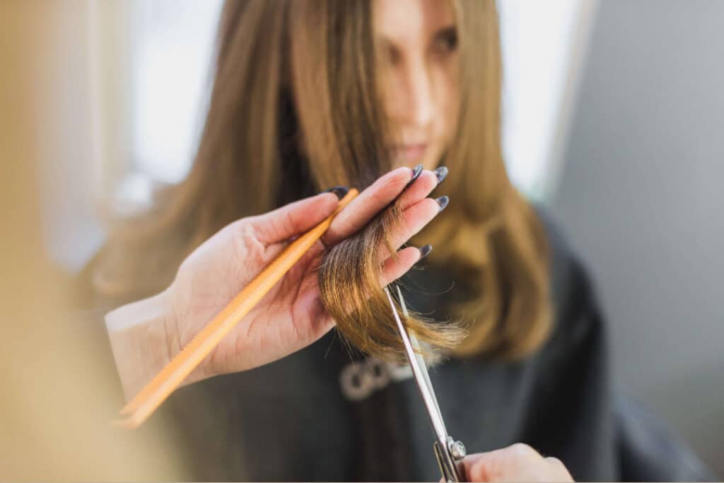 Parrucchiera alle prese con un taglio delle punte dei capelli