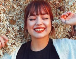 Donna che sorride con la frangia dritta e i capelli rossi