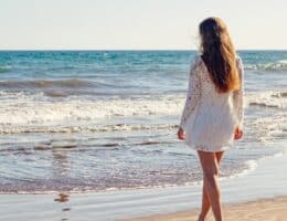 Donna in riva al mare con i capelli castani