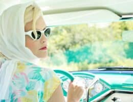 Donna con foulard in testa in macchina vintage