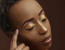 Donna di colore con capelli corti e trucco occhi luminoso