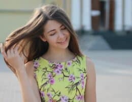 Donna che sorride mentre si accarezza i capelli